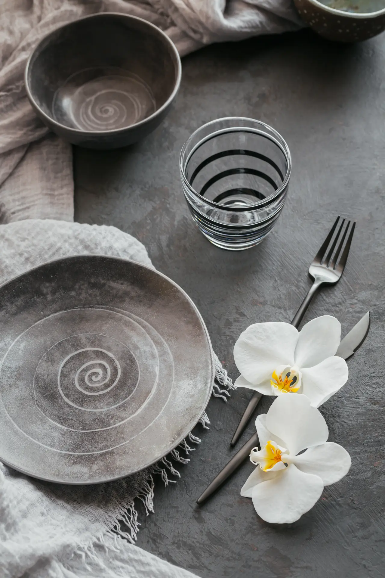 Mesa elegante con vajilla de cerámica y flores blancas