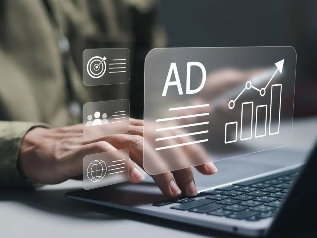 Marketing digital Persona gestionando campañas en un portátil con panel flotante “AD” y métricas de crecimiento, ilustrando la publicidad de Domina Internet en Barcelona.